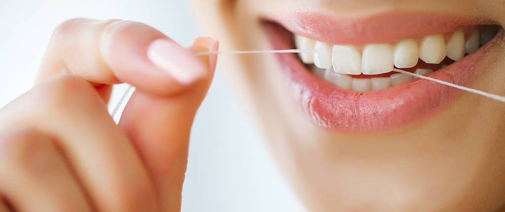 dental-care-woman-with-beautiful-smile-using-floss-teeth-image Mundhygiene Wien für gesunde Zähne
